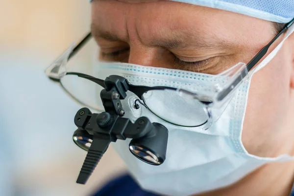 Male surgeon in magnifying glasses with binocular loupes is in a — Stock Photo, Image