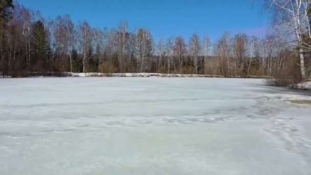 Survol d'un étang gelé au début du printemps 