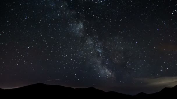 Las estrellas que se mueven en el cielo nocturno sobre las montañas pasan el tiempo. Vía Láctea astronomía — Vídeos de Stock