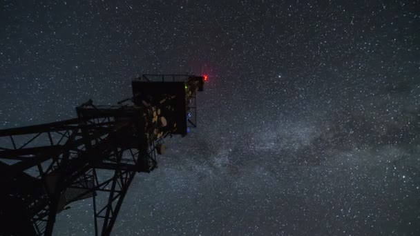Turnul de comunicare în timpul nopții înstelate se scurge. Cerul stelelor în mișcare cu galaxia Calea Lactee — Videoclip de stoc