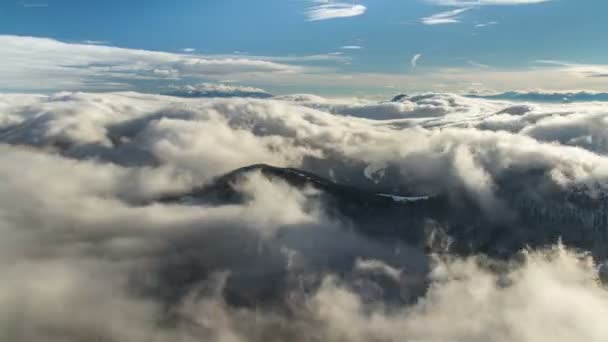 Schöne Wellen niedriger Wolken fließen im Zeitraffer in die Winterberge — Stockvideo