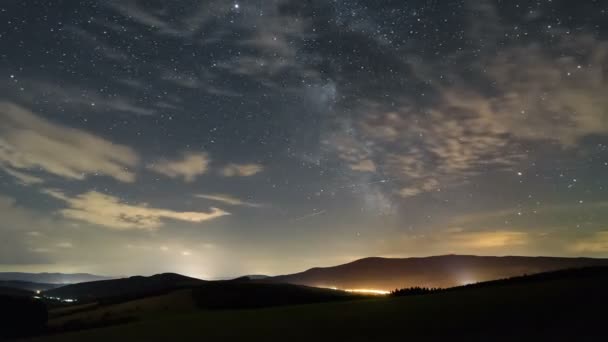 Зоряне небо з галактикою та хмарами, що рухаються над прекрасним пейзажним часом — стокове відео