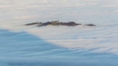 Sis sabah zaman atlamalı ada ormanda. Alçak bulutlar güzel misty dalgaları
