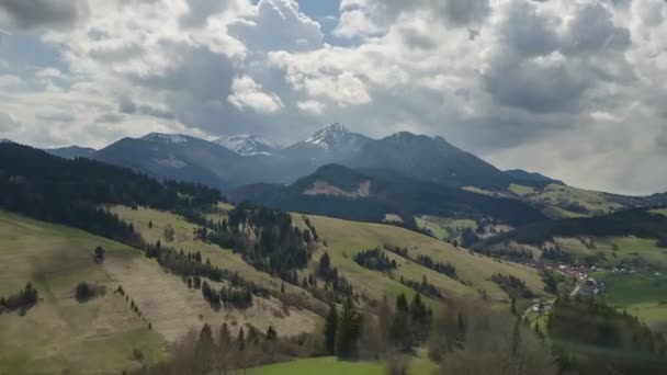 Повітряний політ над весняним пейзажем з хмарами, що рухаються по горах — стокове відео