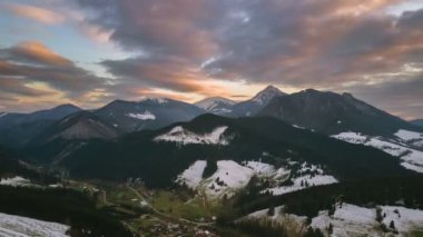 Erken Bahar kırsal manzara içinde karlı dağlar üzerinde renkleri akşam. Hava zaman atlamalı hyperlapse
