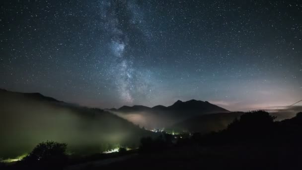 Estrelas com galáxia Via Láctea movendo-se sobre montanhas acima do vale nebuloso em céu estrelado noite lapso de tempo — Vídeo de Stock