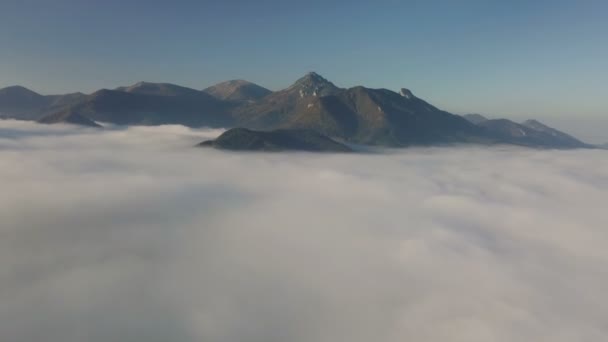 Vuelo aéreo por encima de las nubes en las montañas en otoño paisaje matutino — Vídeos de Stock