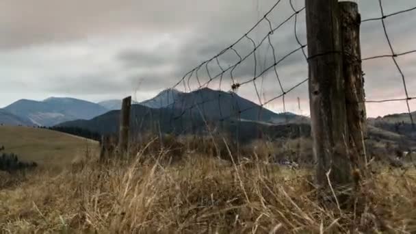 農村の風景を劇的な秋の雲 ドリー ショット フェンスと乾いた草の上 — ストック動画