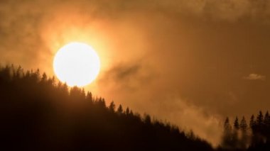 Dramatic sunset over dark forest Time lapse