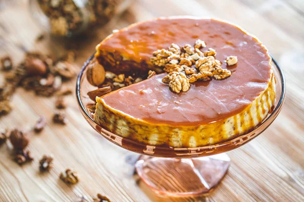 Karamelli ev yapımı chessecake ve ahşap masada ceviz. Lezzetli kahverengi kek tatlısı.