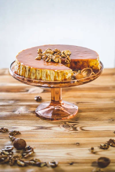 Karamelli ev yapımı chessecake ve ahşap masada ceviz. Lezzetli kahverengi kek tatlısı.