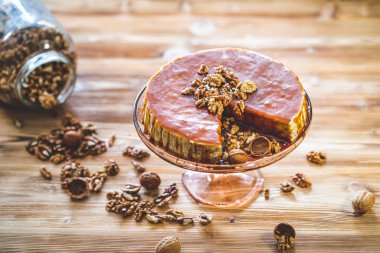 Karamelli ev yapımı chessecake ve ahşap masada ceviz. Lezzetli kahverengi kek tatlısı.