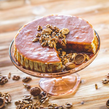 Karamelli ev yapımı chessecake ve ahşap masada ceviz. Lezzetli kahverengi kek tatlısı.