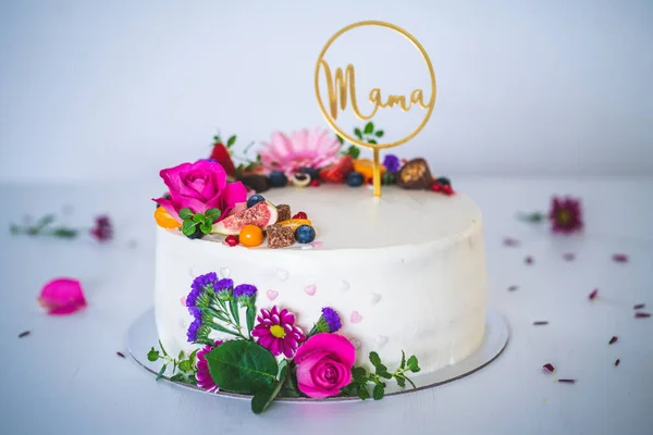 Beyaz ahşap arka planda taze meyve ve gül çiçekli tatlı beyaz peynirli turta. Annemin doğum günü, isim günü ve kutlama için ideal bir hediye..