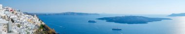 Panoramik kuş hava bakışı beyaz bina, mavi gökyüzü ve canlı deniz Santorini Adası, Oia, Yunanistan