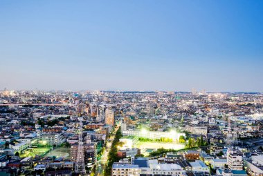 Emlak ve kurumsal inşaat - panoramik modern şehir manzarası kuş göz hava gece görüş dramatik neon kızdırma ve Tokyo, Japonya'da güzel koyu mavi gökyüzü altında iş ve kültür kavramı