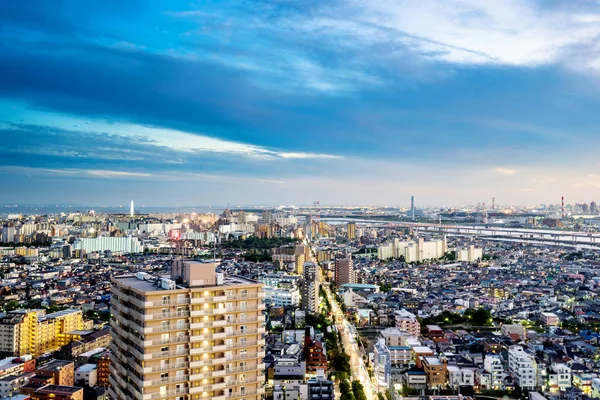 Emlak ve kurumsal inşaat - panoramik modern şehir manzarası kuş göz hava gece görüş dramatik neon kızdırma ve Tokyo, Japonya'da güzel koyu mavi gökyüzü altında iş ve kültür kavramı — Stok fotoğraf