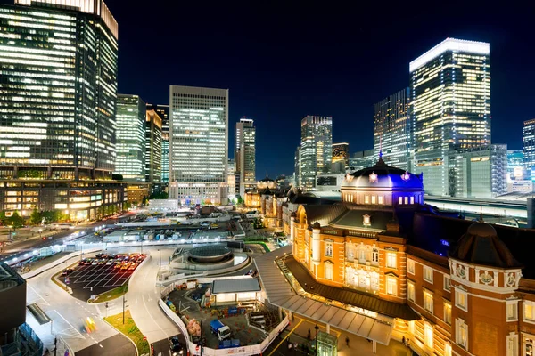 Business concept for real estate and corporate construction - panoramic modern city skyline bird eye aerial night view with tokyo station under dramatic glow and beautiful dark blue sky in Tokyo,Japan