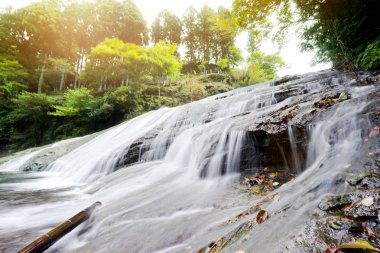 Japan travel concept - beautiful yoro keikoku valley waterfall under dramatic sun glow and morning blue sky in Chiba Prefecture, Japan clipart
