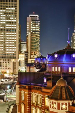 Emlak ve kurumsal inşaat - kuş göz hava gece görünümü altında neon ışık ve koyu mavi gökyüzü Tokyo, Japonya'da Tokyo İstasyonu oluşturma dikey modern cityscape Asya iş kavramı