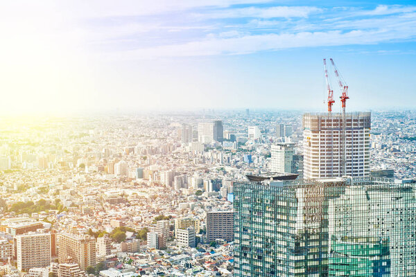 Asia Business concept for real estate and corporate construction - panoramic modern cityscape building bird eye aerial view and cranes under sunrise and morning blue bright sky in Tokyo, Japan