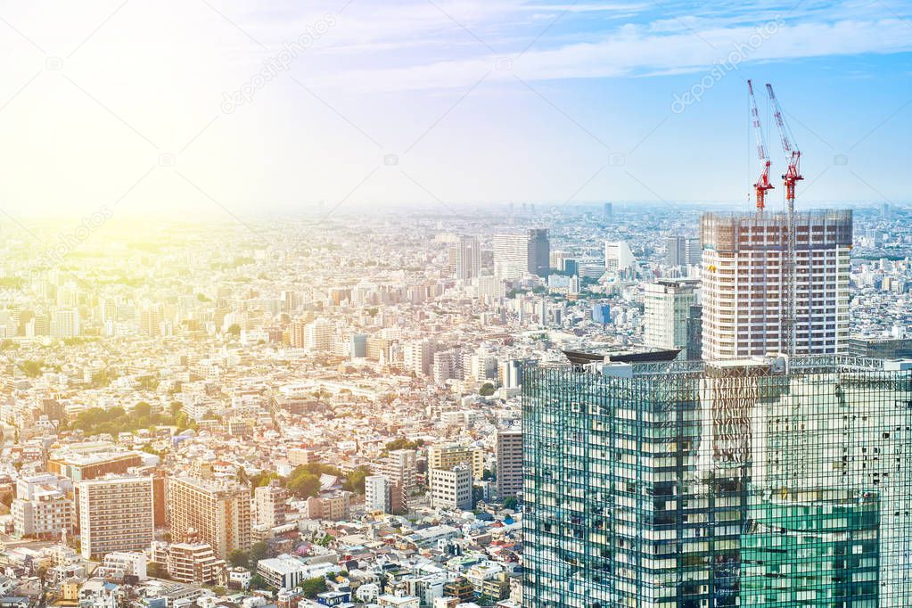 Asia Business concept for real estate and corporate construction - panoramic modern cityscape building bird eye aerial view and cranes under sunrise and morning blue bright sky in Tokyo, Japan