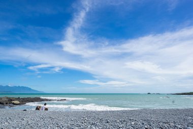 Panoramik manzaralı güzel deniz seviyesi ile resif kayaları fantezi mavi bulutlu ve güneşli gökyüzü altında güzel çift Sansiantai Taitung, Tayvan plajda oturmak