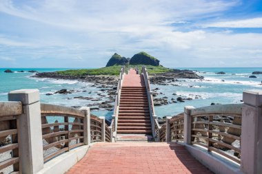 Panoramik Sansiantai Köprüsü ile güzel deniz seviyesi ve resif kayaları Sansiantai Taitung fantezi mavi bulutlu ve güneşli gökyüzü altında. Tayvan ünlü konumlar.