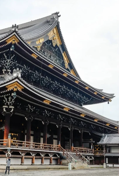 Das berühmte Erbe, traditioneller Tempel Hongan-ji mit goldenem Dach mit Kyoto-Turm im grauen Morgenhimmel in Japan — Stockfoto