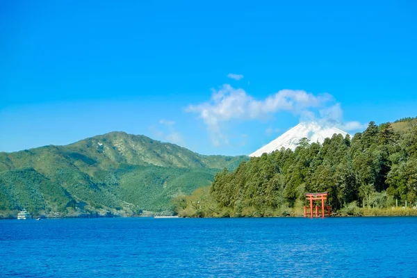 Czerwone torii Brama pod lake Ashinoko z Mount Fuji pod błękitnym niebem słoneczny w Hakone, Japonia — Zdjęcie stockowe