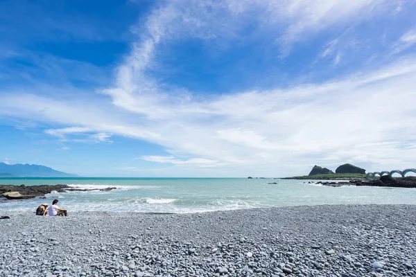 Vista panorâmica do belo nível do mar com rochas recifais sob fantasia azul nublado e sol céu, lindo casal sentar-se na praia em Sansiantai Taitung, Taiwan — Fotografia de Stock