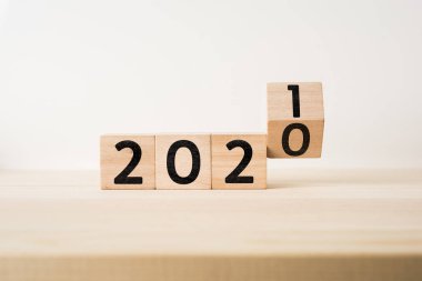 İş ve tasarım konsepti - sürreal soyut geometrik yüzen tahta küp 2020 ve 2019 sözcükleriyle ahşap zemin ve beyaz arka plan