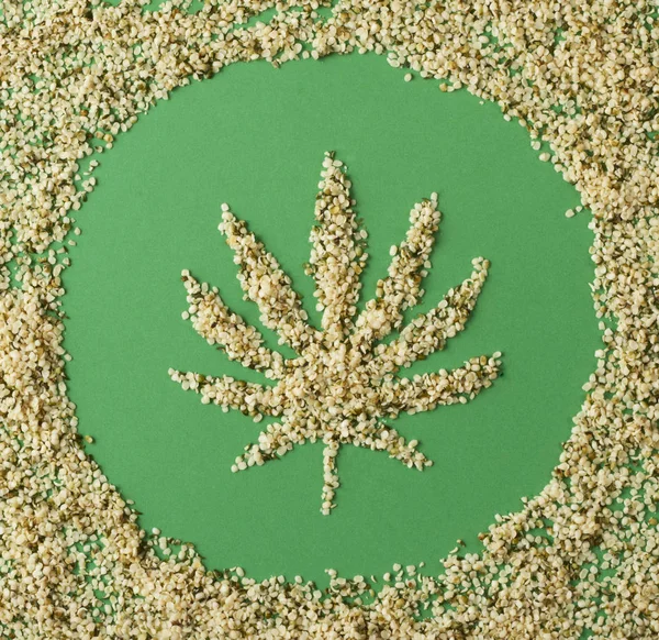 Hampafrön i form av en marijuana blad på en grön bakgrund — Stockfoto