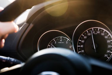 Saatte 120 km hızla giden bir okla yakın çekimli araç hız göstergesi. Detaylar ve arabanın siyah gösterge paneli..