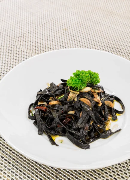 Fresh black aglio olio pasta — Stock Photo, Image