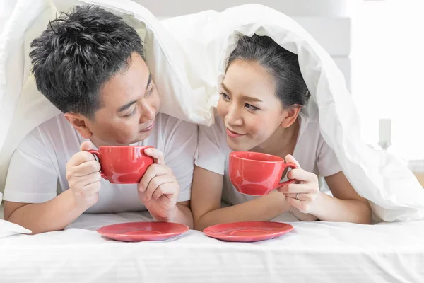 現代のライフ スタイル概念の現代的な家の寝室で一緒にベッドで朝食を有する若いアジア カップル — ストック写真