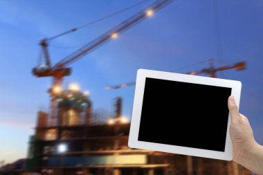 elini tut vinç hareketli alacakaranlıkta şantiye iskele ile dijital tablet 