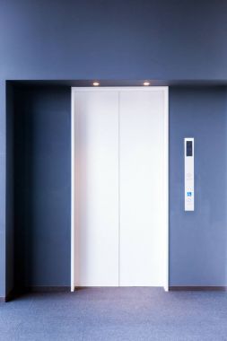 modern bir asansör lobisinde kapalı kapılar ile önden görünümü