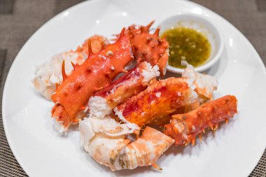 Alaska Kral yengeç ve üzerinde beyaz bulaşık deniz mahsulleri sosu ile deniz ürünleri