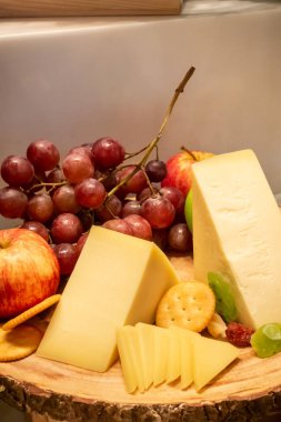 büfe hattında ahşap tabak üzerinde meyve ve kraker çeşitli gruyere peynir