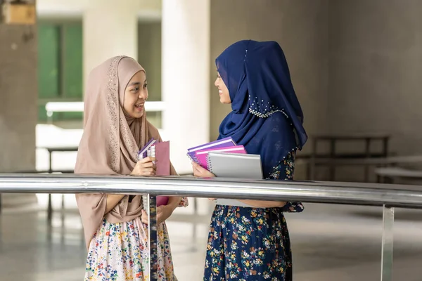 10代の若い大人アジア系タイ人ムスリム大学の学生は本を持ち 教室の外で一緒に話しています 教育の背景概念として — ストック写真