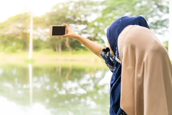 若い大人のティーンイスラム教徒イスラム教徒タイ人女性大学生は 自分の自撮り写真を作るためにスマートフォンを使用して — ストック写真