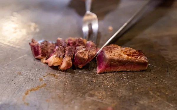 Yemek pişirme teppanyaki tarifi Japon usulü ızgara sığır eti kazıyıcı ve bıçak kullanarak.