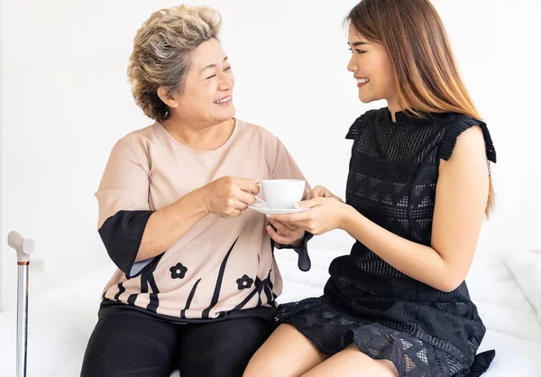 Pflegerin Reicht Alte Frau Kaffee Auf Dem Bett Und Untersucht — Stockfoto