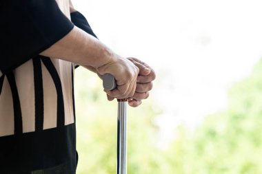 Yürüyen sopayı kapat ya da yaşlı yaşlı kadınların oturma odasında kullandığı bastonu yürüt - iyileşme ve rehabilitasyon konsepti