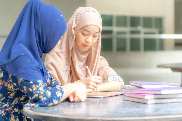 ティーネージャー ヤング アダルト アジアタイ ムスリム大学の学生は本を読んだり デジタルタブレットを一緒に使用して教育やオンライン教育の概念 — ストック写真