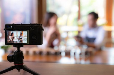 Genç Asyalı girişimci kafe kahve dükkanının video bloğu ve kafedeki kamerayla çevrimiçi pazarlama için sosyal medyada yaşıyor. Küçük işletme oluşturma ve tüketim kavramının başlangıcı için kullanılacak. 