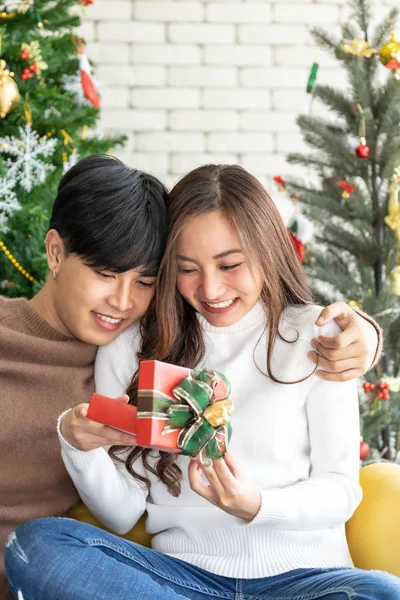 美しい幸せなアジアの女の子オープンクリスマスプレゼントギフトボックスから彼女のボーイフレンドのためのクリスマスホリデーシーズン挨拶 — ストック写真