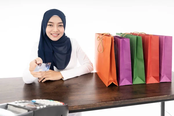幸せな笑顔の女性イスラム教徒の女性は消費者主義とショッピングのコンセプトとして使用するEdcマシンとクレジットカードで彼女のショッピングのために支払うことを確信しています 白い背景で撮影したスタジオ — ストック写真
