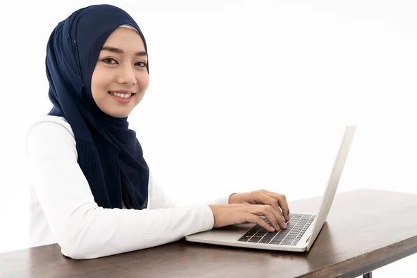 ラップトップ検索を使用してヒジャーブを身に着けているアジアの若い大人の女性とオフィスワークを白地に隔離 オフィス ビジネス ワークステーションのコンセプト — ストック写真
